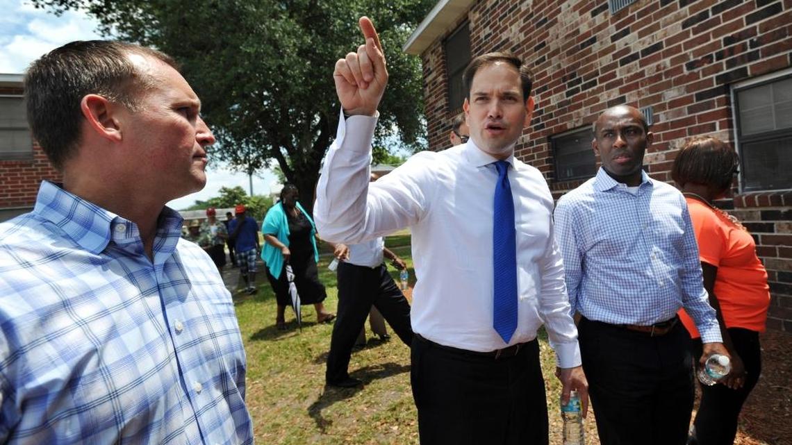 Sen. Marco Rubio talks about conditions at Eureka Garden apartments in Jacksonville with Mayor Lenny Curry, left, and city council member Garrett Dennis.