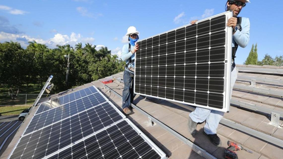 Martin Cabrera and Joseph Molina of Cutler Bay Solar Solutions install solar panels at a home in South Miami-Dade on Friday, November 13, 2015.