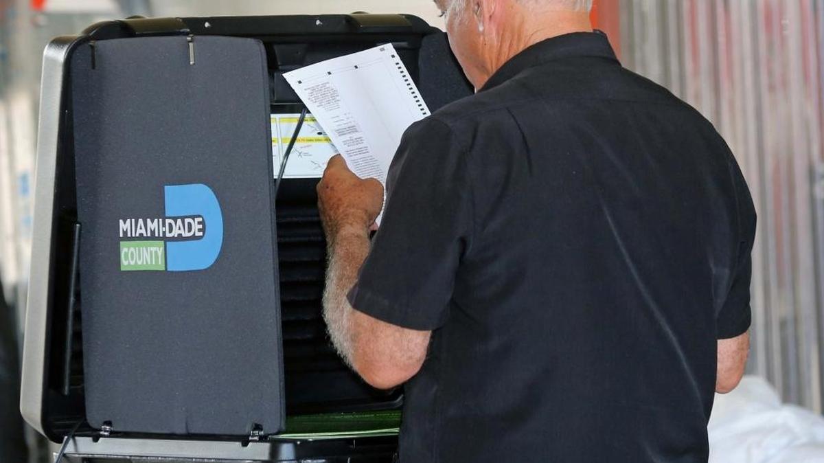 A voter checks his ballot before submitting it at a Hialeah precinct during primary voting August 30, 2016.
