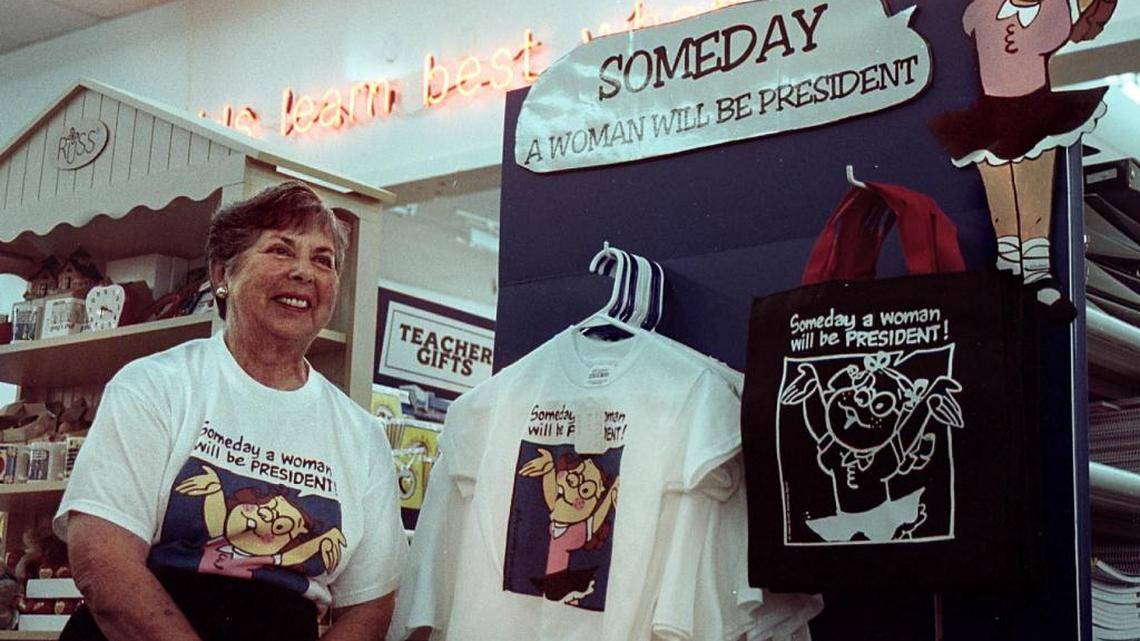 Dr. Ann Moliver Ruben of Weston sits with her "Someday a Woman Will Be President" items for sale at the ACE Educational Company in Davie. About eight years ago, the T-shirts erupted a controversy at a Miramar Wal-Mart when corporate headquarters banned the shirts from South Florida shelves. Feminist groups picketed across the country.