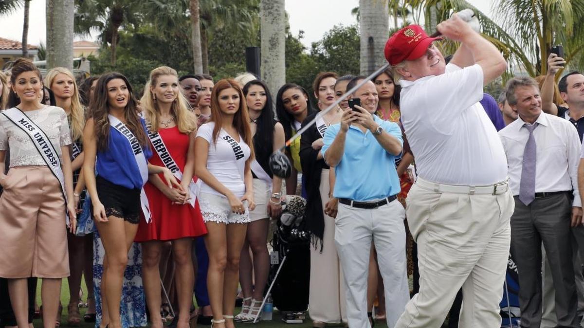 Donald Trump tees off at the Trump National Doral in this file photo from Jan. 12, 2015. Miss Universe contestants watched in the background.