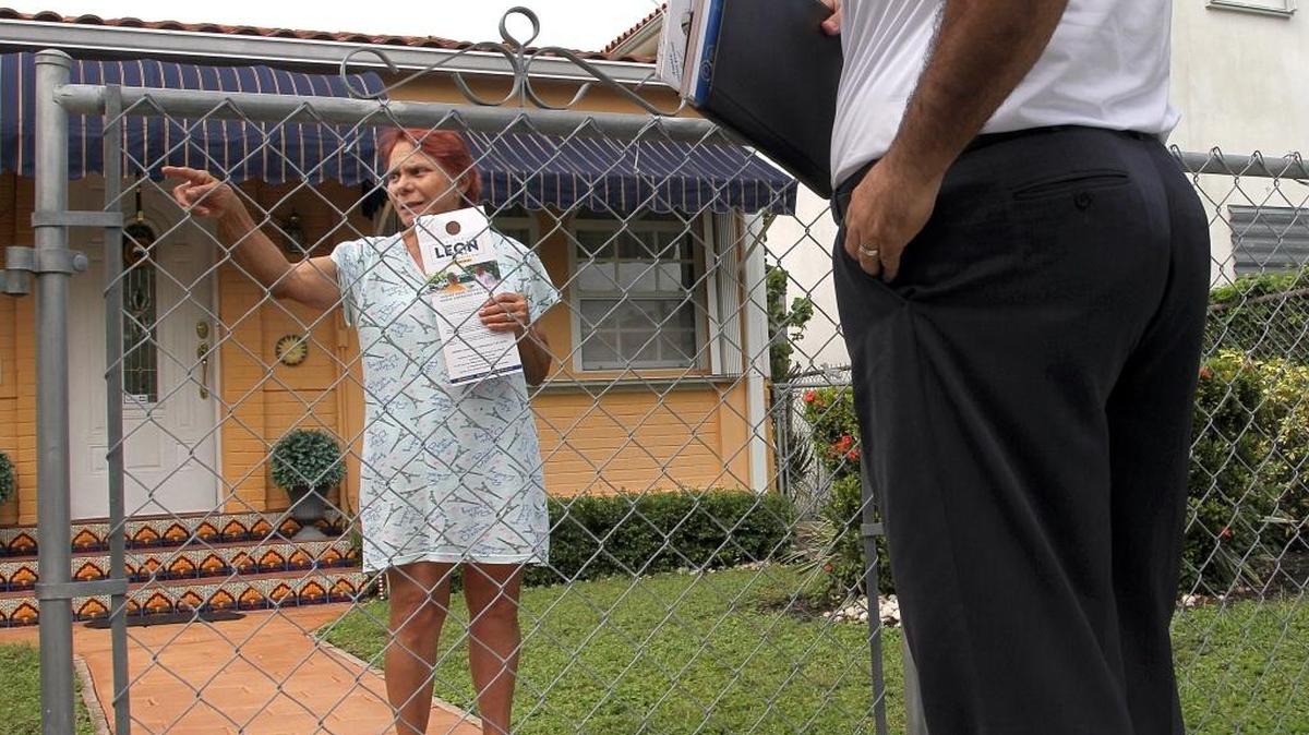 Miami Commission candidate Alfie Leon talks with Ileana Cabanas, left, a resident voter, as he stops to talk with residents and hand out campaign materials in Miami’s Shenandoah and Roads neighborhoods on Oct. 3.