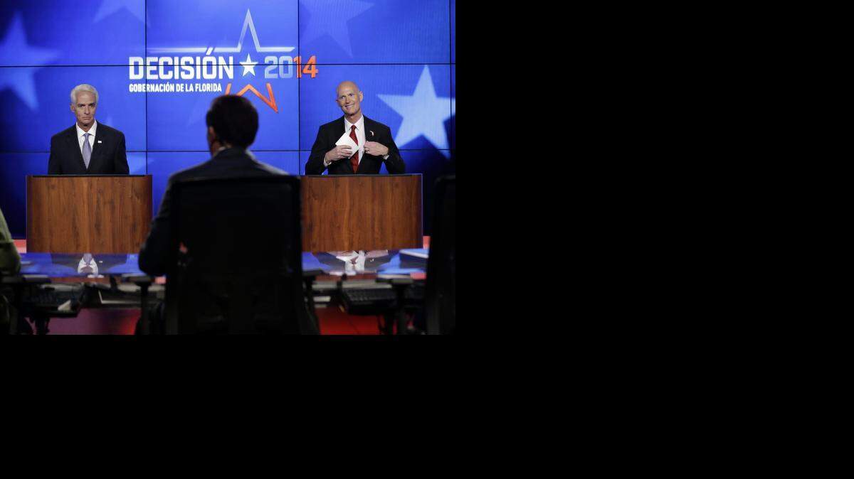 
Democrat Charlie Crist, a former Republican governor of Florida, left, and Florida Republican Gov. Rick Scott, right, prepare to leave after a gubernatorial debate at the Spanish-language network Telemundo 51, Friday, Oct. 10, 2014, in Miramar, Fla. This is the first of three debates before the November election. 
