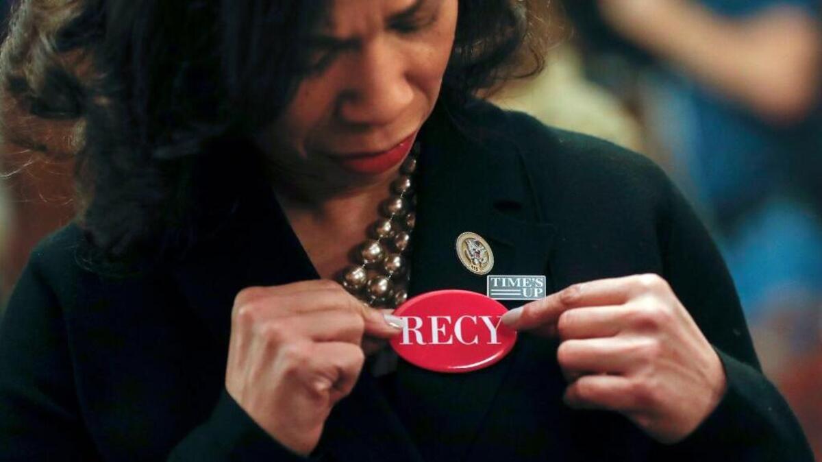 Rep. Lisa Blunt Rochester, D-Del., adjusts her RECY button as she joins other House members in wearing black in support of the #metoo and #timesup movement, ahead of Tuesday’s State of the Union address on Capitol Hill in Washington, Tuesday, Jan. 30, 2018. Members of the Congressional Black Caucus and members of the Democratic Caucus wore red pins in memory of Recy Taylor. Taylor was abducted and raped while walking home from work in Alabama in 1944.