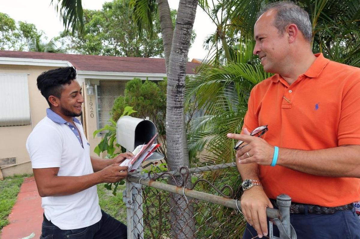 District 3 commission candidate Tommy Regalado speaks to resident Arten Lopez while campaigning on Wednesday.