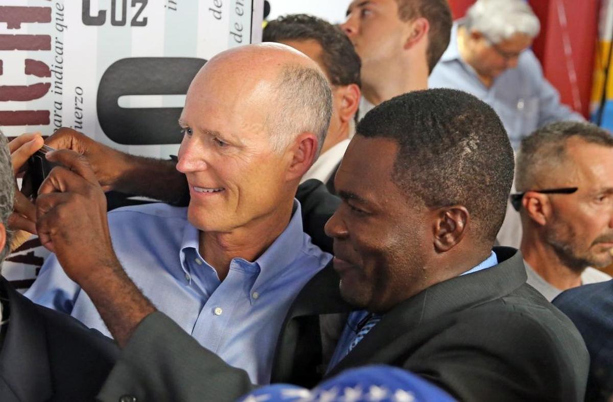 Florida Gov. Rick Scott has his photo taken with Pastor Gabriel Aemosthene after Scott talked to members of the Venezuelan community at El Arepazo restaurant in Doral, July 10, 2017.