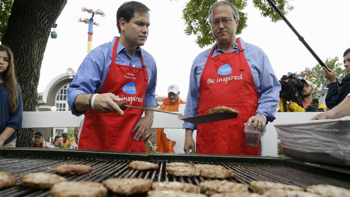 
Republican presidential candidate, Sen. Marco Rubio, R-Fla., works the grill in the Iowa Pork Producers Tent with Rep. David Young, R-Iowa, right, during a visit to the Iowa State Fair, Tuesday, Aug. 18, 2015, in Des Moines, Iowa. 
