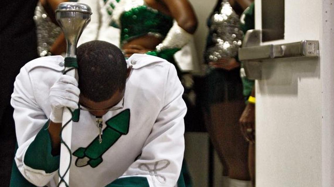 Drum Major Andre Young kneels in prayer in the doorway prior to performing with Miami Central High School band in May 2009.