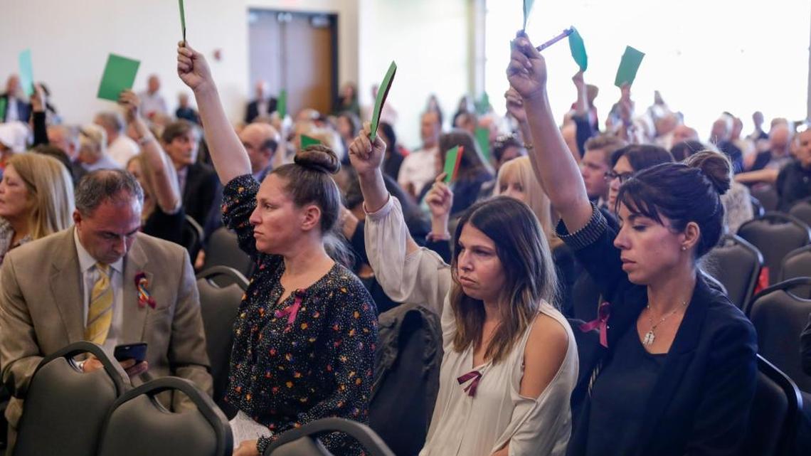 Kim Bankoff, of Weston, left, Tamara Levine, center, of Parkland, and Amanda Savastano., right, of Parkland, hold up green cards in support of better gun safety legislation during the Road to the Ballot Public Hearing Tour at University of South Florida St. Petersburg’s Student Center on Tuesday, March 13, 2018 in St. Petersburg.