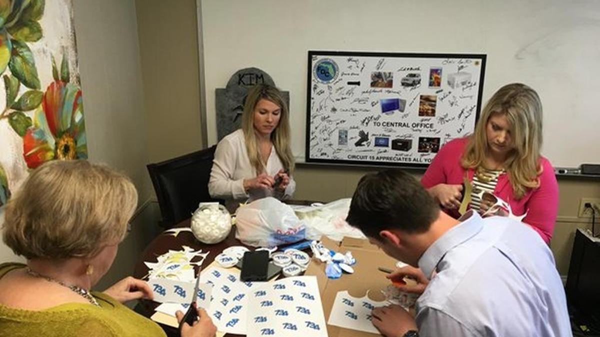 Department of Corrections Secretary Julie Jones works with staff on creating homemade buttons and stickers to distribute to legislators to promote her efforts to get legislative approval for 734 new corrections officers in the budget. From left: Jones, McKinley Lewis, communications director, Kim Banks, FDC budget chief, Sharon Rudd, Jones' executive assistant.