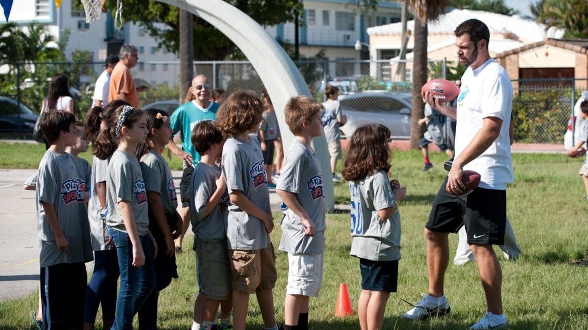 Brandon Fields, then a punter with the Miami Dolphins, runs drills with students at North Beach Elementary School during a celebration of the school's winning of the National Football League Play 60 Super School contest, Jan. 14, 2014, in Miami Beach.