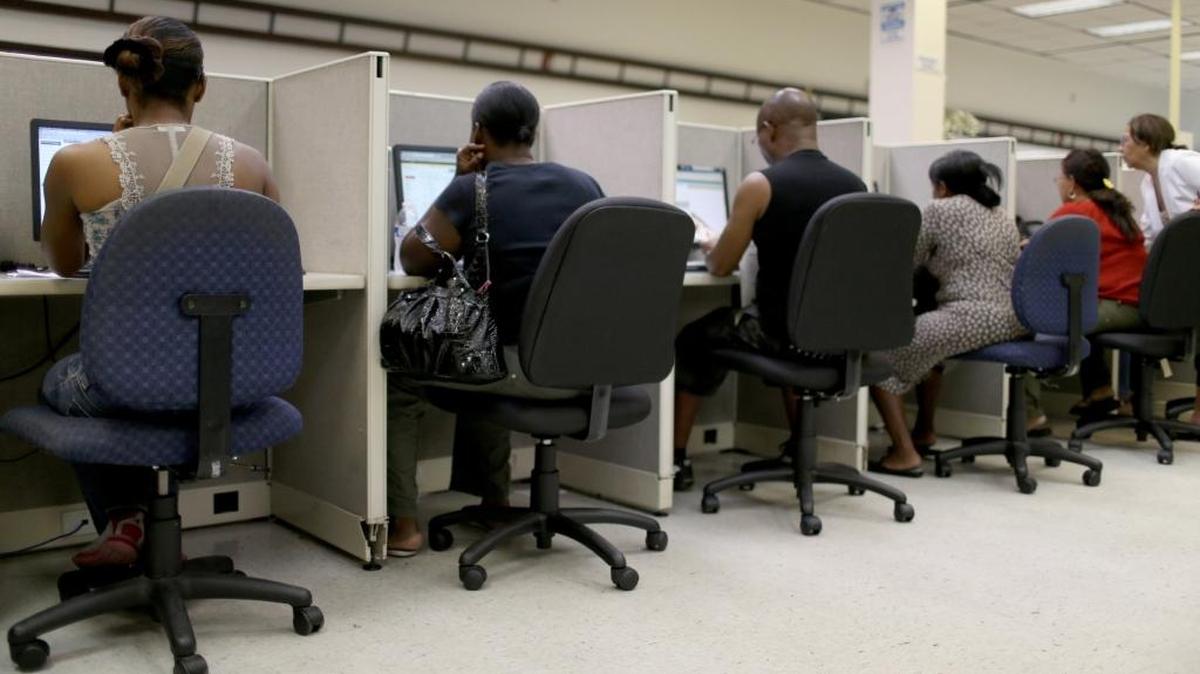 People look for job opportunities on the computers at CareerSource Florida on Aug. 1, 2014 in Miami. The requirement proposed by the Florida House can be met by being employed or taking part in job training and preparation with CareerSource Florida, a quasi-private agency that connects businesses to potential employees.