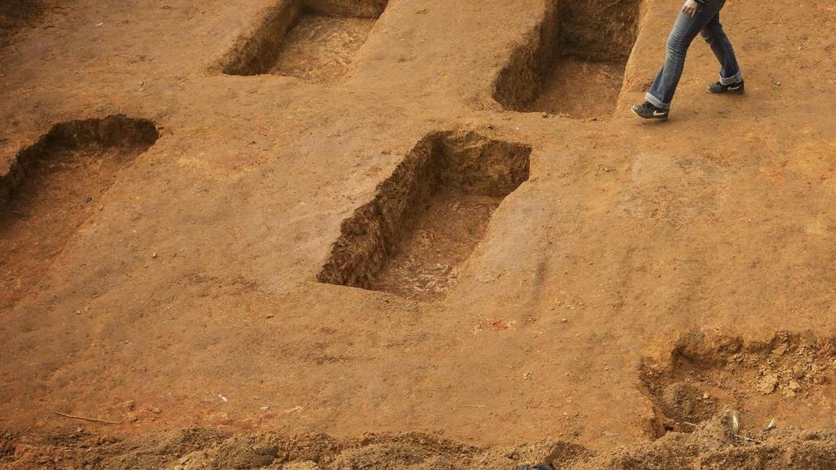 
University of South Florida assistant professor of anthropology Dr. Erin Kimmerle passes open graves in December 2013 at the Boot Hill cemetery at the Arthur G. Dozier School for Boys. Researchers from USF removed dozens of sets of human remains.
