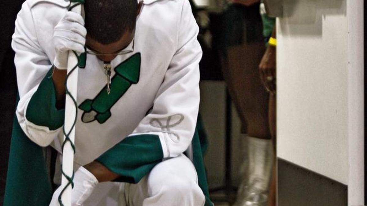 Drum Major Andre Young kneels in prayer in the doorway prior to performing with Miami Central High School band in May 2009. Lawmakers in Tallahassee want to fortify students’ and teachers’ rights to express their religious beliefs in Florida public schools.