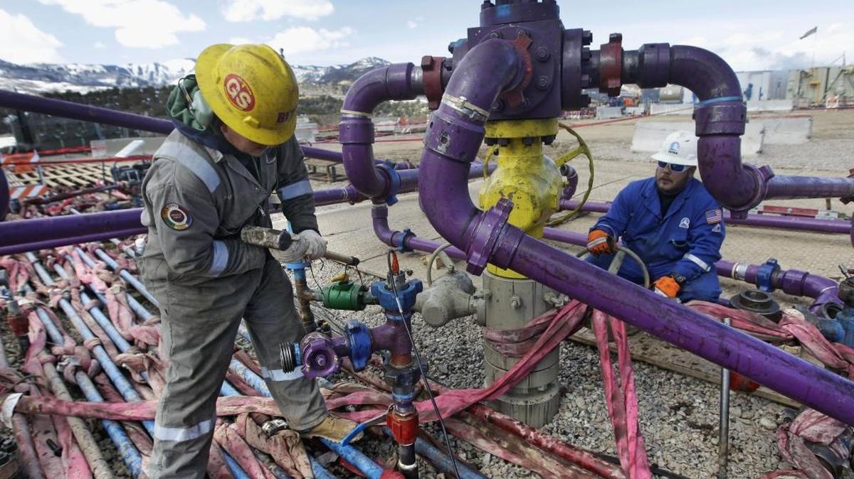 In this March 29, 2013 file photo, workers tend to a well head during a hydraulic fracturing operation at an Encana Oil & Gas Inc. gas well outside Rifle, in western Colorado.
