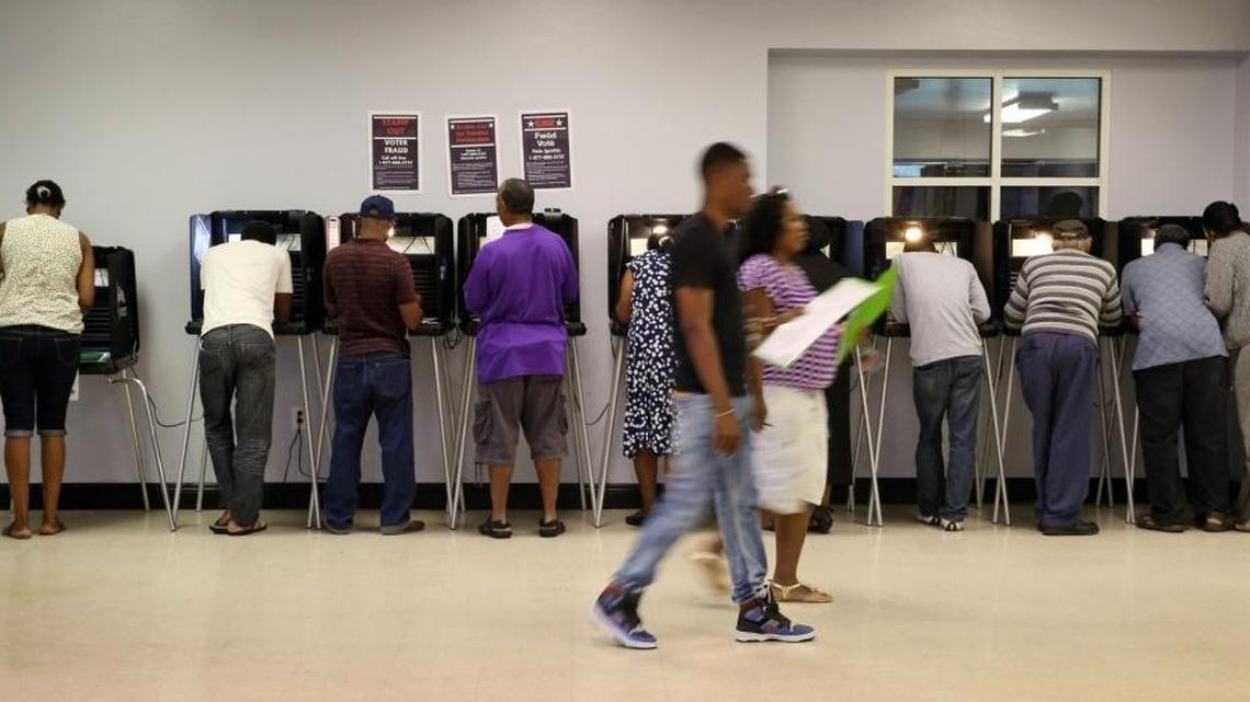 People stand at voting booths marking their ballots inside North Miami’s Sunkist Grove Community Center on election day, Nov. 4, 2014.