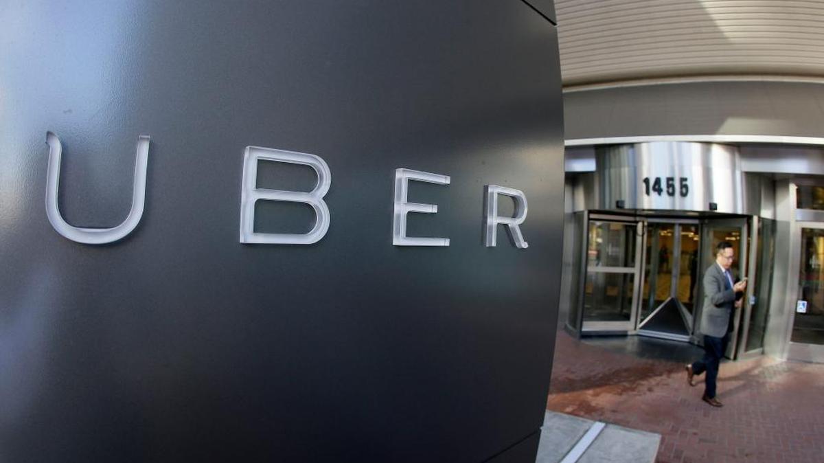 In this Dec. 16, 2014, file photo a man leaves the headquarters of Uber in San Francisco.