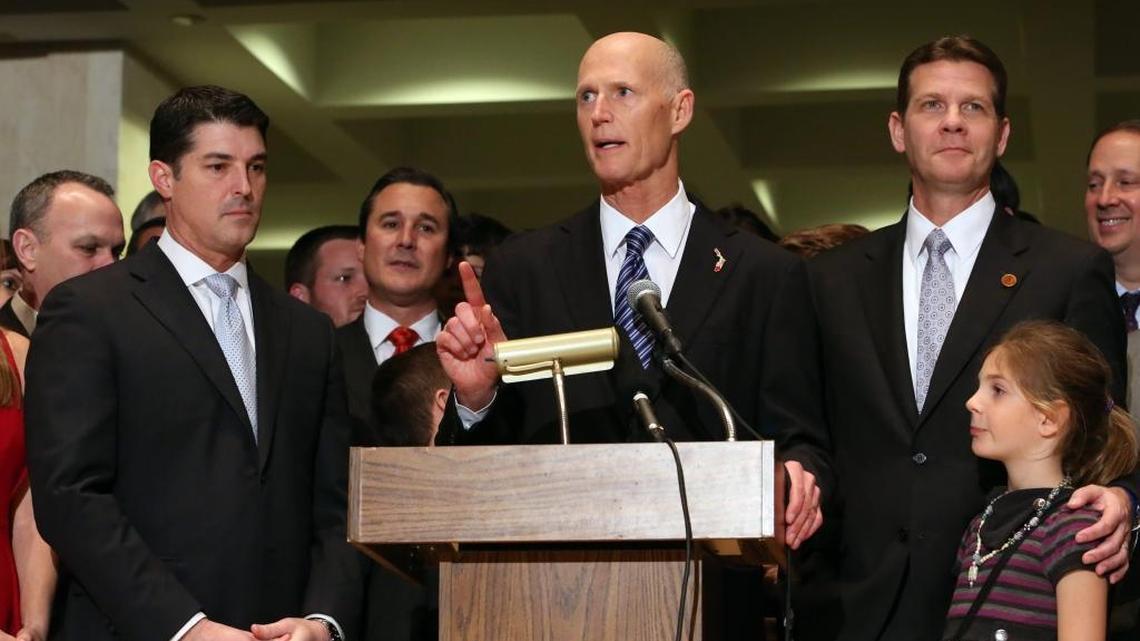Gov. Rick Scott addresses the crowd flanked by House Speaker Steve Crisafulli, R-Merritt Island, left, and Senate President Andy Gardiner, R-Orlando, at the end of session, Friday, March 11, 2016, in Tallahassee.
