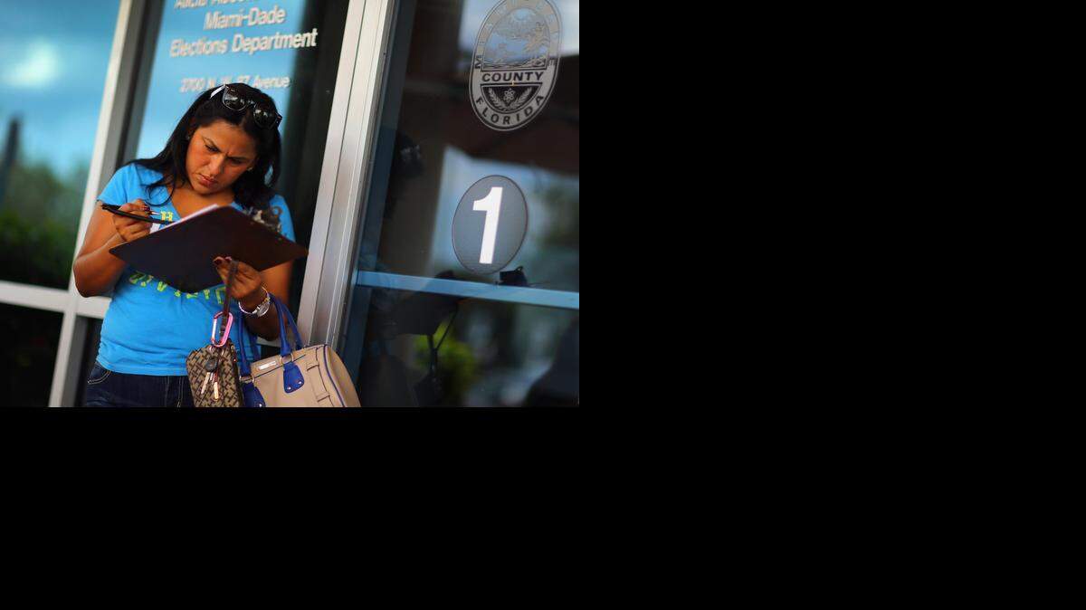 
Ereyda Monge fills out her voter registration form at the Miami-Dade Elections Department in this 2012 file photo.
