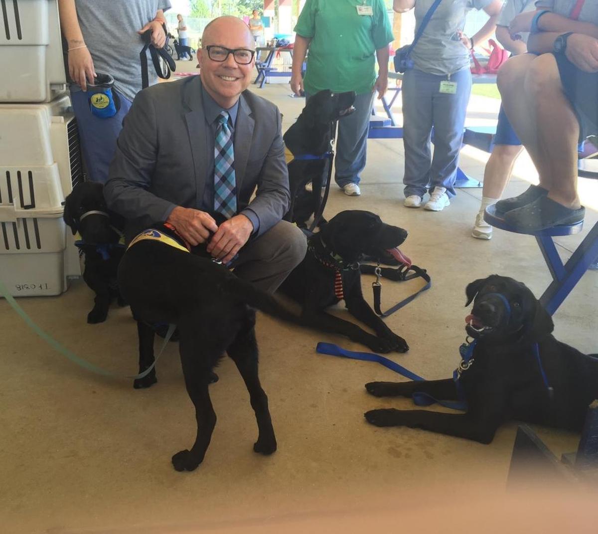 Rep. David Richardson, D-Miami Beach, sees a dog training program at Gadsden Correctional Facility during one of his earlier visits to the privately run women’s prison in North Florida. Inmates are in the background.　