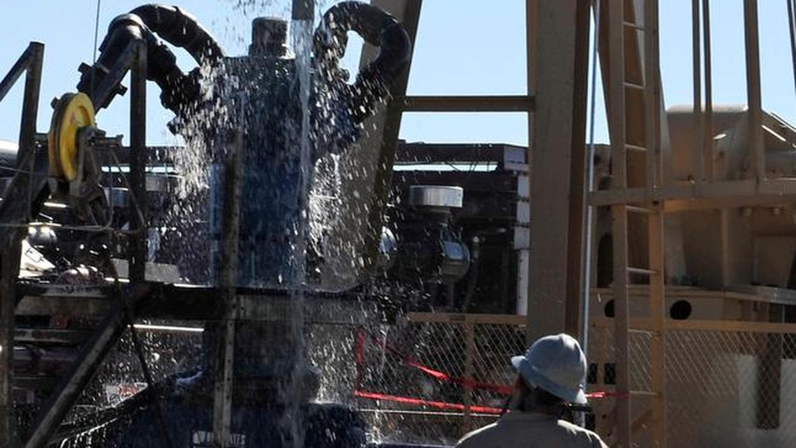 Water gushes out of a drilling pipe as it is pulled up to be replaced with a fresh pipe at a hydraulic fracturing site in Midland, Texas, Sept. 24, 2013. The drilling method known as fracking uses huge amounts of high-pressure, chemical-laced water to free oil and natural gas trapped deep in underground rocks.