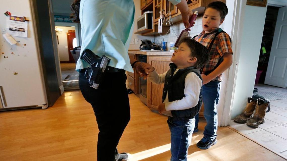 Gun-rights advocate, restaurant owner and mother of four sons, Lauren Boebert, wears her usual gun on her hip as she brushes the hair of Roman, 3, as the family gets ready to leave home for church in Rifle, Colo., on May 1, 2016.