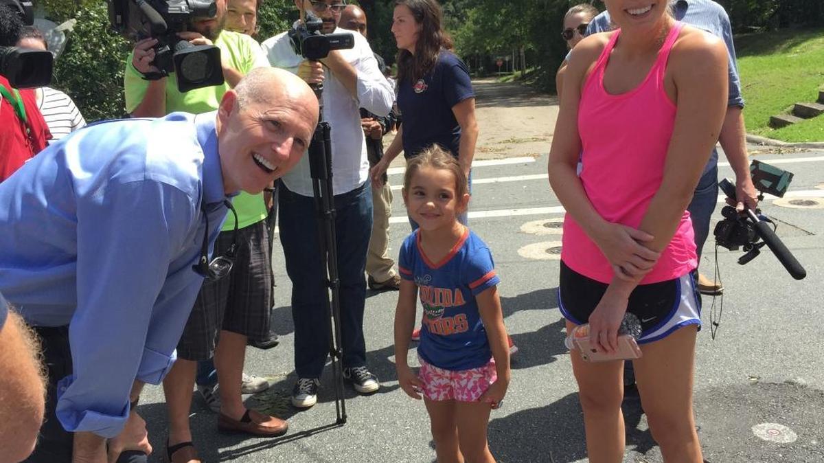 Gov. Rick Scott speaks with 5-year-old Stella Corum and her mother Beth while touring damage from Hurricane Hermine in Tallahassee, Friday, Sept. 2, 2016.