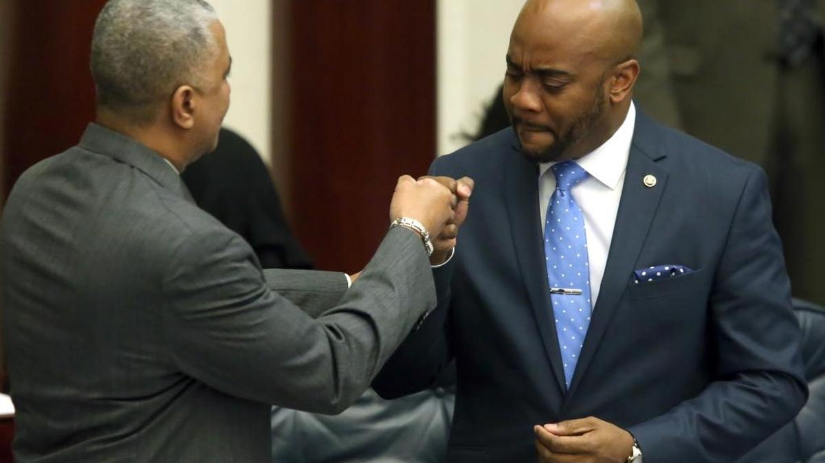 Rep. Alan Williams, D-Tallahassee, right, gives a fist bump to fellow Rep. Dwayne Taylor, D-Daytona Beach, during a debate on an alimony bill during session, Tuesday, March 8, 2016, in Tallahassee.