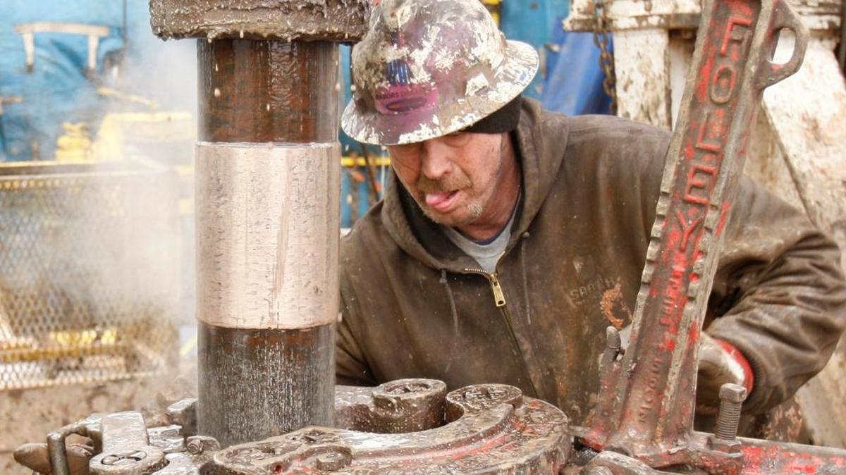 Deckhands on a Sandridge Energy oil rig change out a drill pipe in a fracking operation on the Oklahoma border in Harper County, Kan., in February 2012.