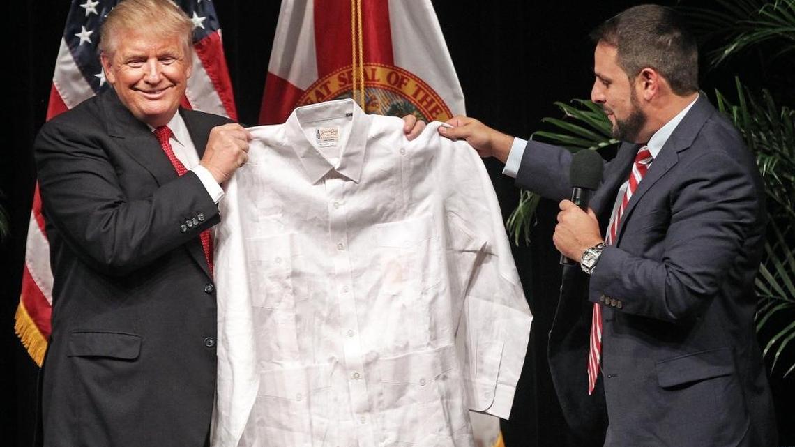 State Rep. Carlos Trujillo presents Republican presidential candidate Donald Trump with a classic linen Cuban Guayabera after a townhall-style meeting at the Miami Dade College Koubek Center on Tuesday, September 27, 2016