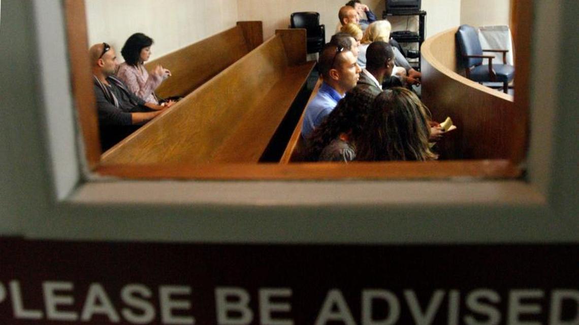 People wait to have their uncontested divorce cases heard, ruled upon and finalized in December 2010 sit in a courtroom presided over by Judge Arthur Birkin during the 17th Judicial Court’s Family Pro Se Day at the Broward County Courthouse