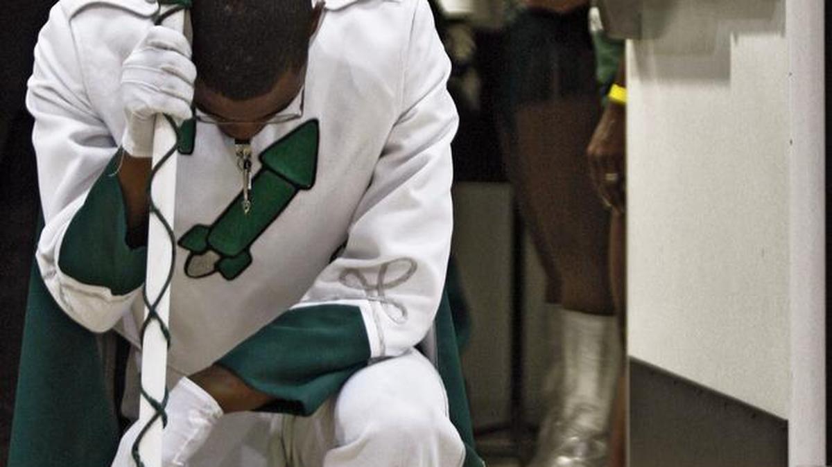 Drum Major Andre Young kneels in prayer in the doorway prior to performing with Miami Central High School band in May 2009.