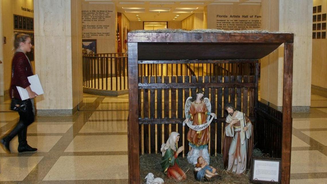 A woman walks past the Christmas nativity scene installed at the Florida Capitol in Tallahassee, Dec. 3, 2013.