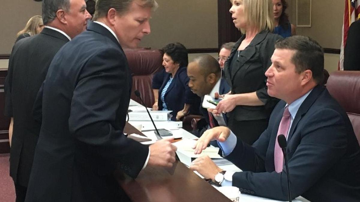 Enterprise Florida CEO Chris Hart, left, speaks to State Sen. Jeff Brandes, R-St. Petersburg, after a committee meeting on Feb. 15, 2017. Hart suddenly resigned on Monday.