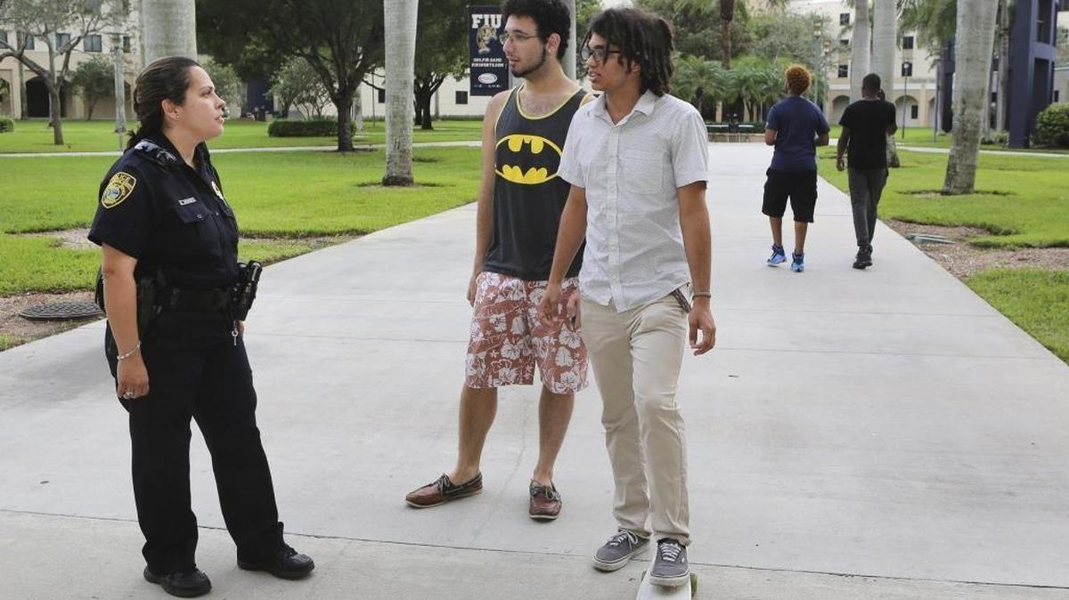Florida International University police officer Sonia Meneses, left, chats with FIU students Colin Lugo, center, and Christian Colevas on Thursday, Nov. 19, 2015 at FIU’s Modesto A. Maidique Campus. For the second consecutive year, Florida’s public university system is requesting additional funding for more police officers and campus counseling resources. The Legislature ignored the system’s request for 2016-17.