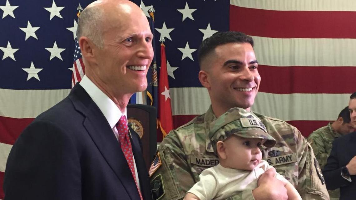 Florida Gov. Rick Scott poses with a deploying soldier from the 260th Military Intelligence Battalion on Friday, April 6, 2018, at Miami’s Florida National Guard Robert A. Ballard Armory.