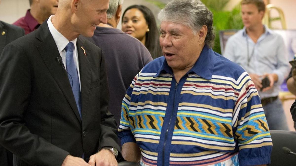 In this February file photo, Gov. Rick Scott talks with James Billie, Seminole Tribe of Florida chairman, at the tribe’s headquarters. The tribe is suing the state over new rules on toxin levels in drinking water.