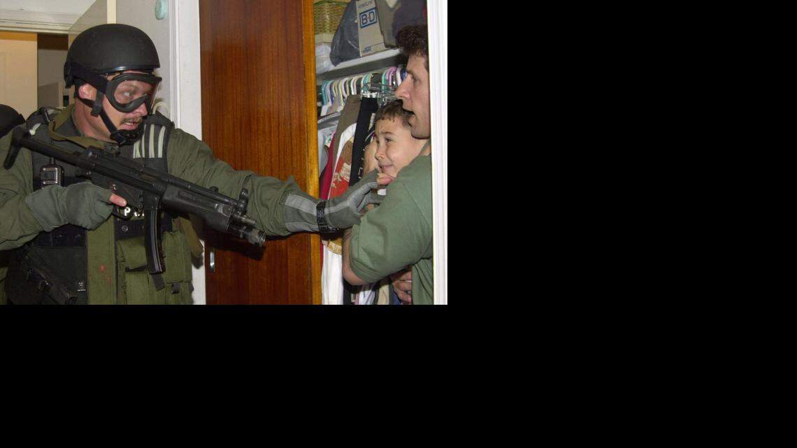 
Elián González is held in a closet by Donato Dalrymple, right, as government officials search the home of Lázaro González for the young boy on April 22, 2000.

