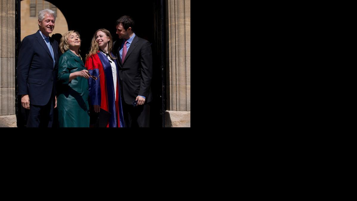 
This, May 10, 2014, file photo, shows Former U.S. Secretary of State Hillary Rodham Clinton as she takes off her sunglasses to pose for a group photograph with her husband former U.S. President Bill Clinton, left, their daughter Chelsea, second right, and her husband Marc Mezvinsky, as they leave after they all attended Chelsea's Oxford University graduation ceremony at the Sheldonian Theatre in Oxford, England. 

