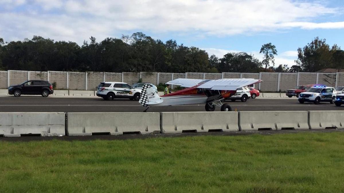 A small airplane lands in the center, closed lanes of I-4 in Seminole County, Florida, on Nov. 3.