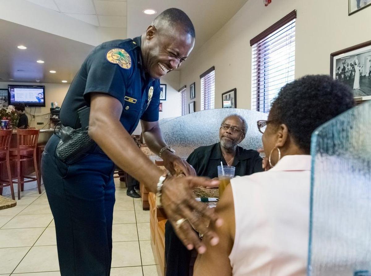 Major Delrish Moss, left, visits with Tim and Annie Bostic at their booth at the Jackson Soul Food restaurant in the Overtown section of downtown Miami, Florida on Wednesday, May 13, 2015. Moss is in charge of Miami Police Department’s Community Relations Section. 