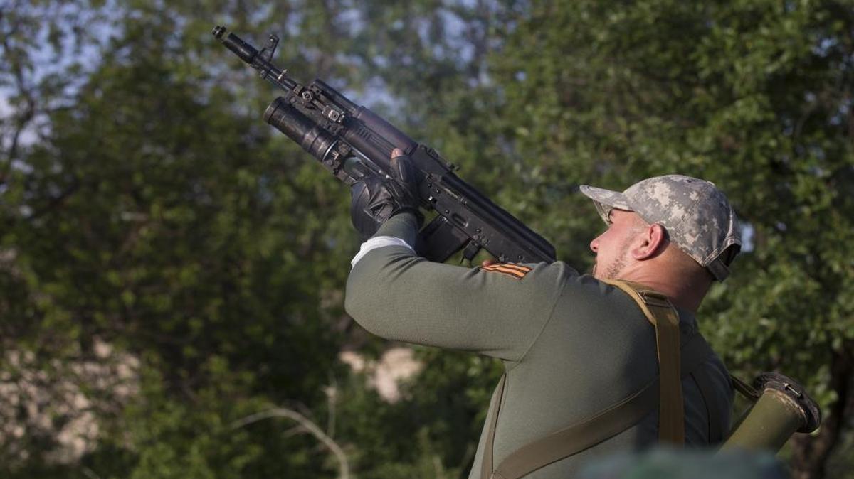 A pro-Russian man shoots grenade launcher against Ukrainian government troops at a checkpoint outside Slovyansk, eastern Ukraine, Thursday, May 15, 2014. On Thursday, Ukraine's acting president, Oleksandr Turchynov, claimed the Ukrainian army destroyed an insurgent base in the city of Slovyansk and another one in nearby Kramatorsk, about 150 kilometers (95 miles) west of the Russian border.
