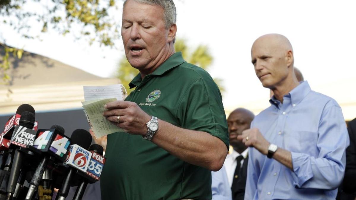 Orlando Mayor Buddy Dyer reads details of the shootings at Pulse nightclub during a media briefing Monday. Gov. Rick Scott at right.