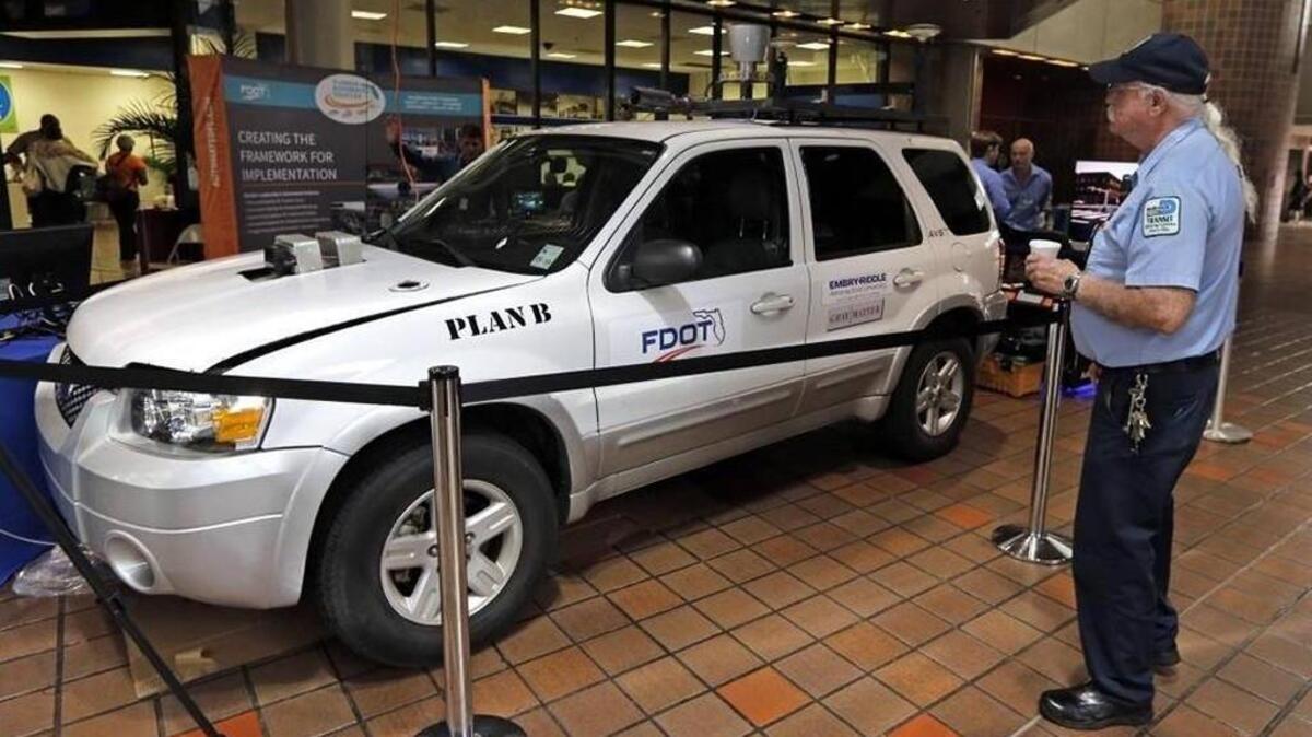 Anthony Ruvalo checks out the driverless car, Plan B, being demonstrated and on display at the Miami-Dade Government Center lobby on March 31, 2016.