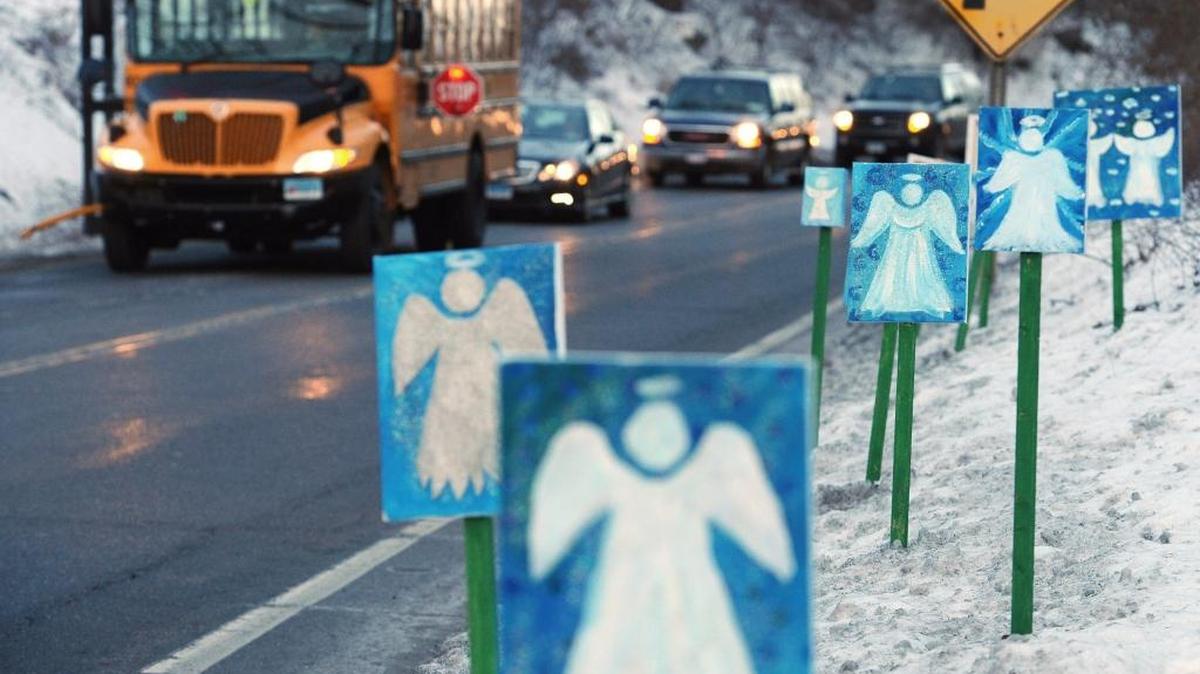 A bus traveling from Newtown to Monroe, Conn., stops in front of 26 angels along the roadside on the first day of classes for Sandy Hook Elementary School students since the Dec. 14, 2012 shooting.