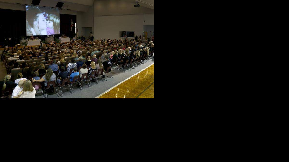 
Photos of Sarah Spirit and her children are displayed on the screen during a Memorial service at Bell High School for the victims of Thursday's shootings on Sunday, Sept. 21, 2014, in Bell, Fla. Police say Don Spirit shot and killed his daughter, Sarah, and her six children before turning the gun on himself.
