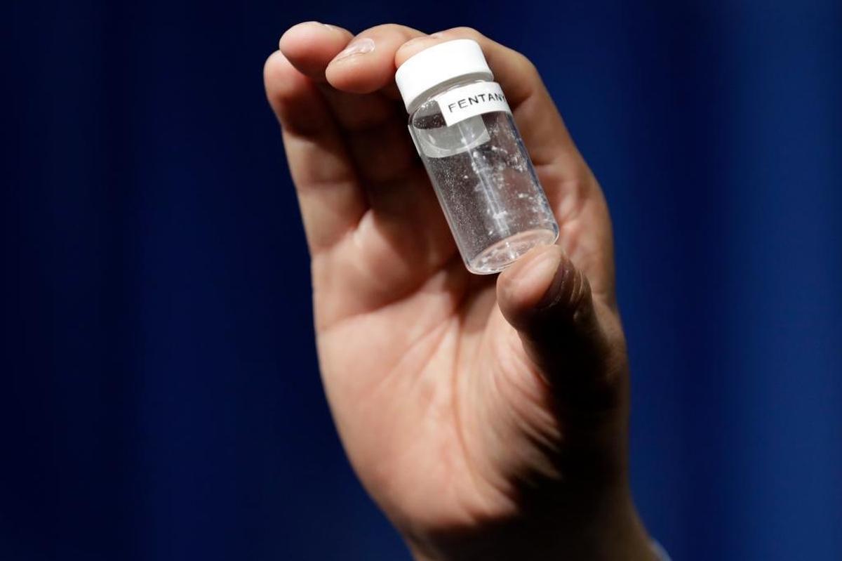 A reporter holds up an example of the amount of fentanyl that can be deadly at DEA Headquarters in Arlington Virginia, June 6, 2017.