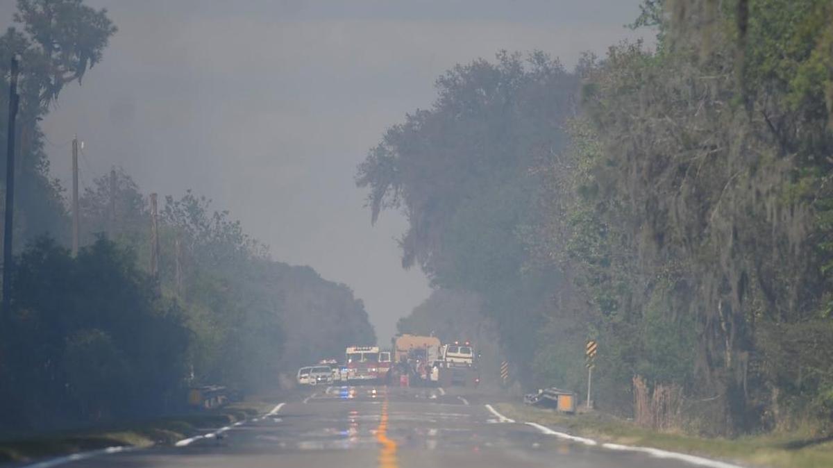 Smoke is visible along State Road 37 in the Duette area of northeastern Manatee County following the crash of a twin-engine plane Saturday afternoon. Numerous emergency vehicles and personnel responded to assist at the crash site and fight a resulting wildfire in the heavily wooded area.