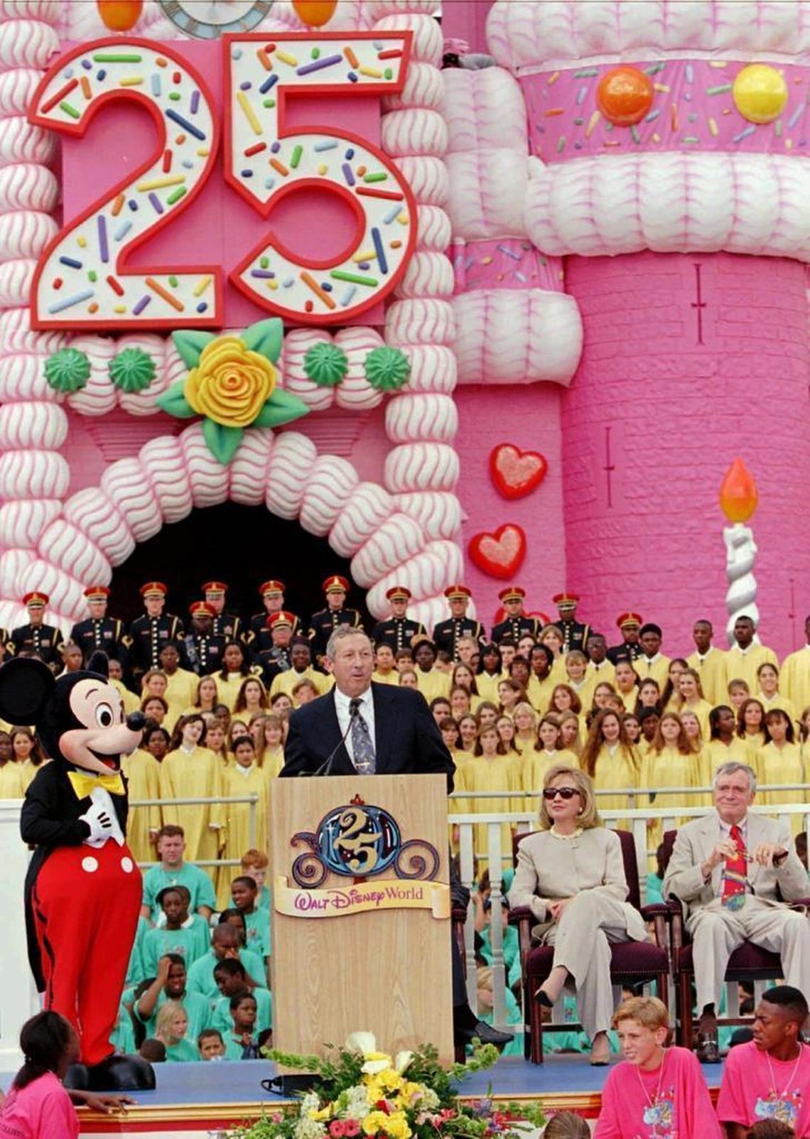 Roy Disney, second from left, nephew of Walt Disney, addresses the crowd along with Mickey Mouse, First Lady Hillary Rodham Clinton, and Fla. Governor Lawton Chiles during the 25th anniversary rededication ceremonies Tuesday, Oct. 1, 1996, at Walt Disney World in Lake Buena Vista, Fla.