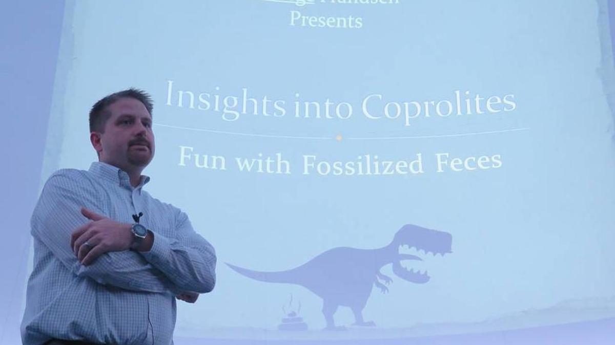 George Frandsen, 37, speaks about coprolites -- fossilized feces -- Wednesday evening at the South Florida Museum in downtown Bradenton.